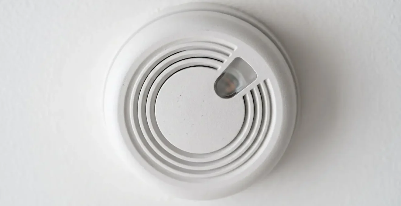 Détecteur de fumée connecté moderne installé au plafond pour prévenir les risques d'incendie électrique